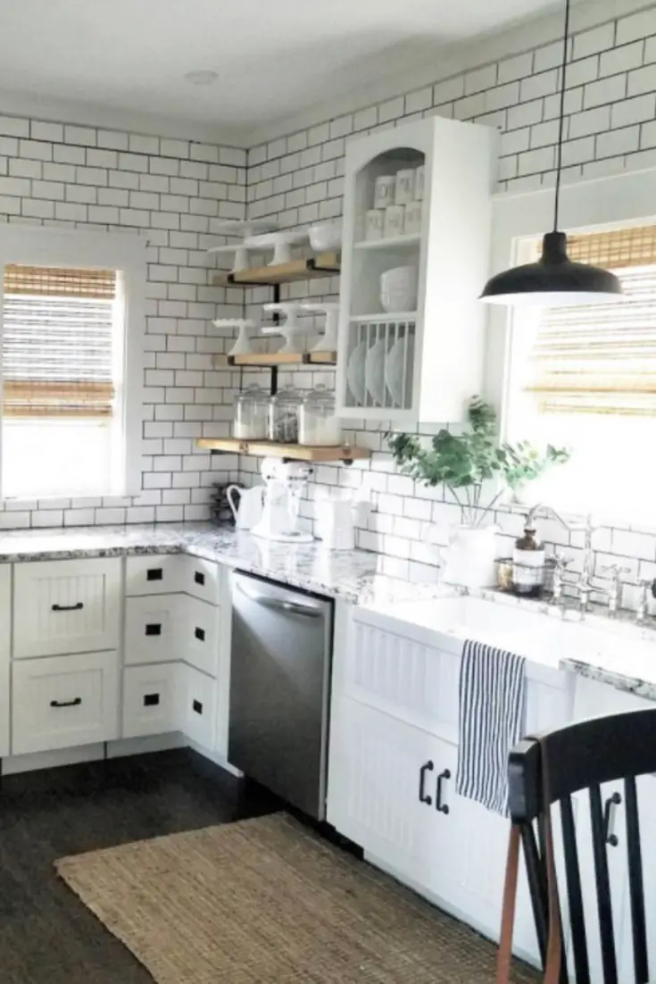 This kitchen is just STUNNING with the use of subway tile, open shelving, open kitchen cabinets, big white farmhouse sink and updates everywhere.  What a great DIY kitchen makeover idea!