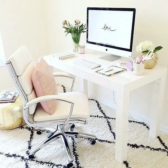 This home work space shows how even a SMALL area can be the perfect home office area.  The white desk and white office chair keep it all looking bright and neat - and organized.  The pink throw pillow adds a nice soft touch of feminine color - and that black and white rug is a perfect finishing touch.