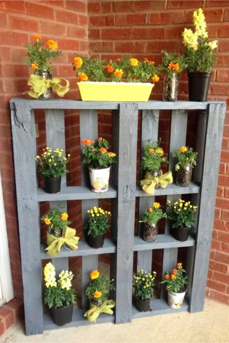 This is pretty yet such an easy DIY pallet project!  Take an old pallet, paint the wood and turn it on it's side to use as an outdoor flower shelf for your potted plants.