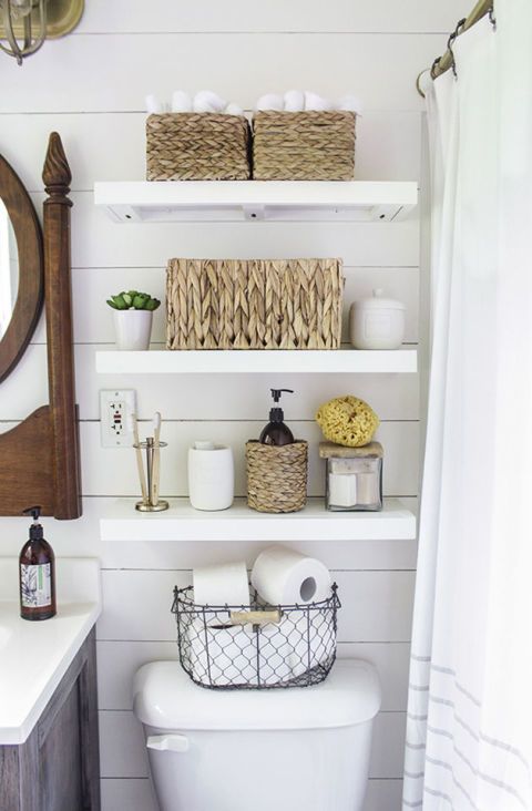 DIY white floating bathroom shelves over the toilet in a country farmhouse bathroom.