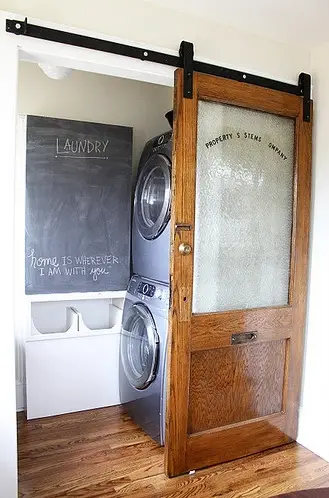 Tiny laundry room idea with stacked washer dryer - this unused closet transformed into a laundry room.  LOVE the sliding door!