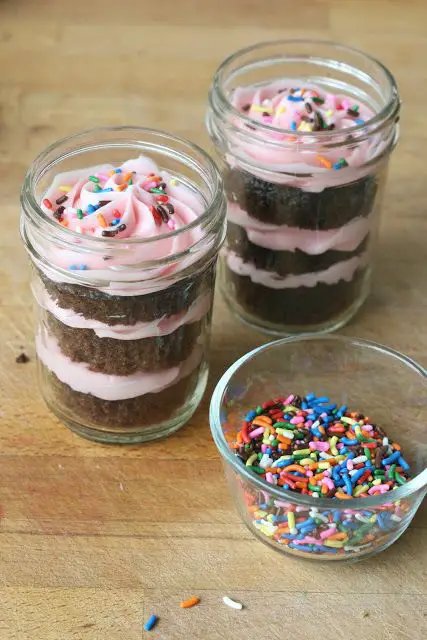 Cupcakes in a Jar!  These easy Mason Jar cupcakes would be great for a birthday party!  Love the pink icing and use of sprinkles