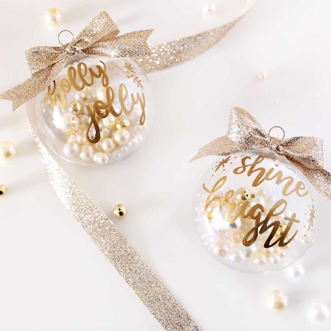 Easy handmade Christmas ornaments - LOVE all these Ideas for Decorating Clear Christmas Balls - Clear Christmas tree balls filled with pearls, fun Holiday sayings painted on in pretty lettering, and topped with metallic ribbon bows.
