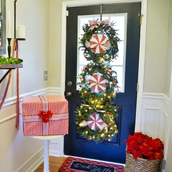 Front door decorated with a triple wreath for Christmas