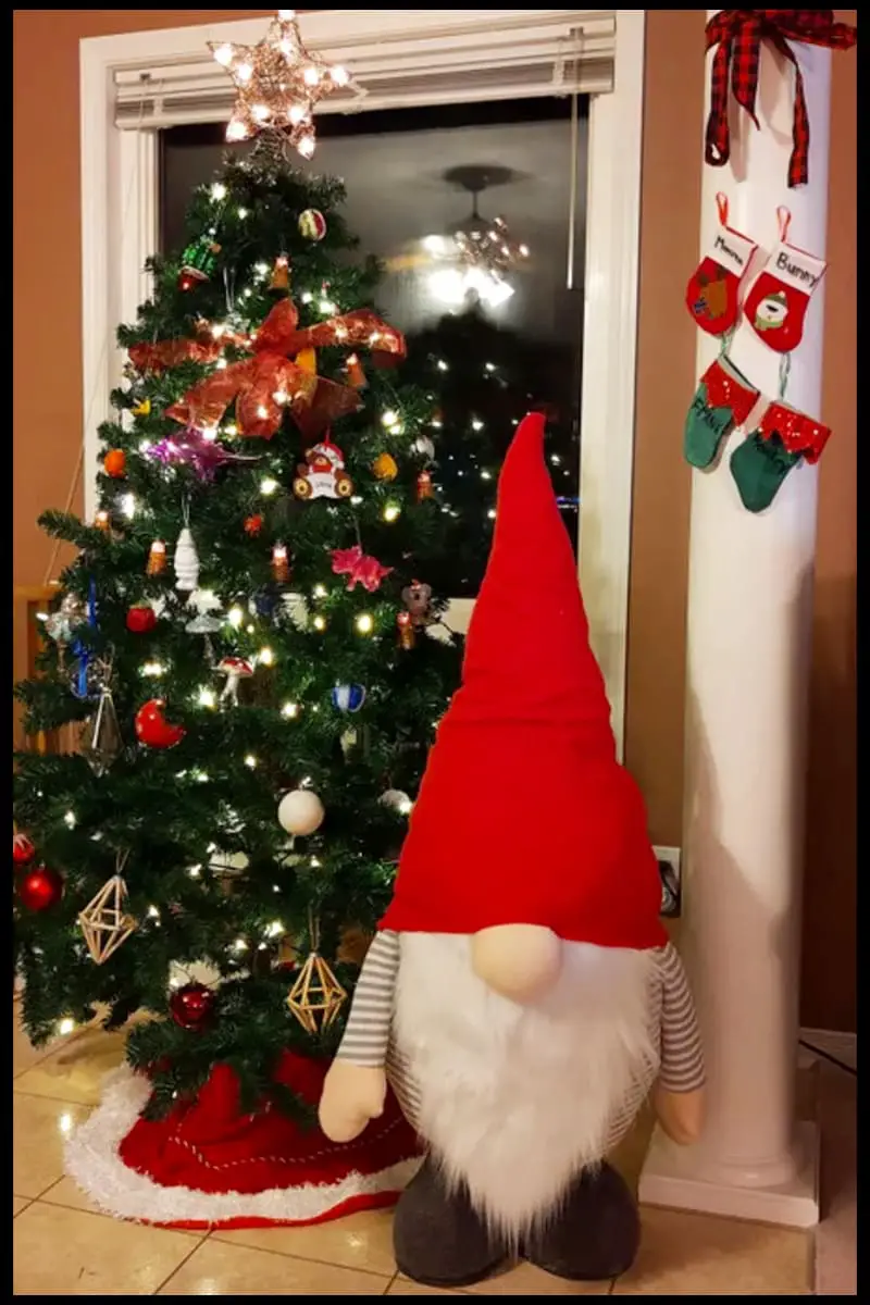 Tall free standing gnome next to Christmas tree