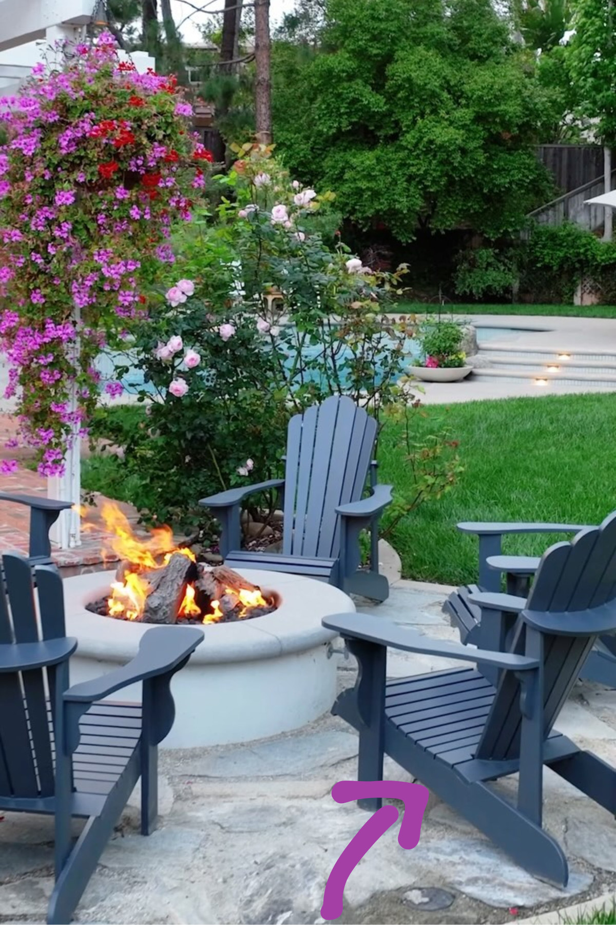 Backyard fire pit area with inground pool landscaped yard and flowers with concrete patio